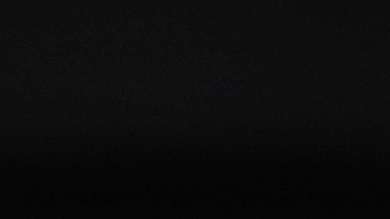 White spheres appear in various positions against a black grid background, showing dynamic movement.