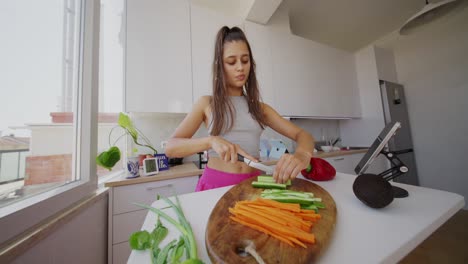 young woman chopping vegetables in a bright kitchen