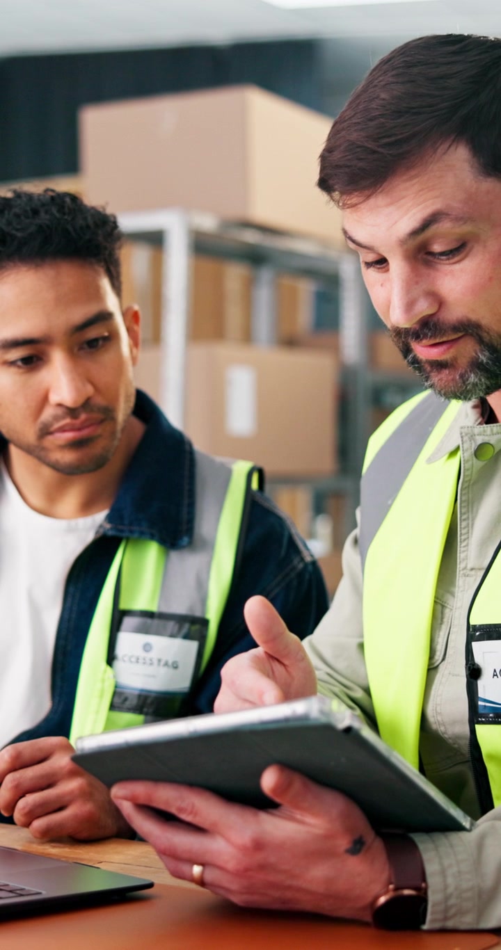 Responsabili di magazzino che analizzano i dati logistici su tablet e laptop