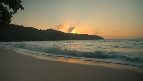 Hermosa-Playa-En-Seychelles-Al-Atardecer-Con-El-Océano-Y-Las-Montañas-A-La-Vista