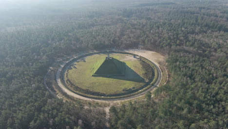flying towards austerlitz pyramid in beautiful forest in the netherlands. the piramide van austerlitz is a monument in the netherlands, built in 1804 as a tribute to napoleon bonaparte.