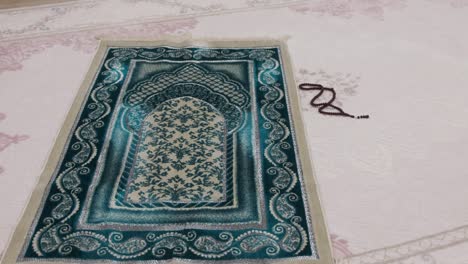alfombra de oración puesta para orar, oración de color verde y rosario, alfombras de oración y rosario en el islam,