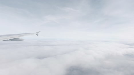 View-out-of-a-plane-window-over-the-United-Kingdom-in-Slow-Motion-during-a-cloudy-day