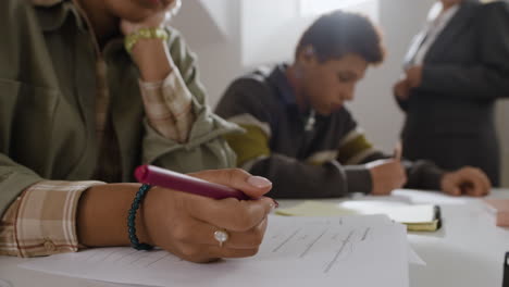 students writing on paper in classroom
