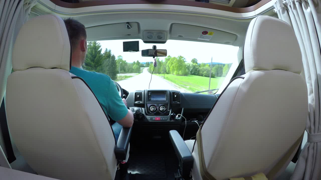 캠퍼 밴 (rv) 의 도로에서 운전하는 남자