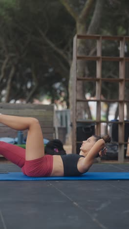 mujer haciendo ejercicios abdominales al aire libre