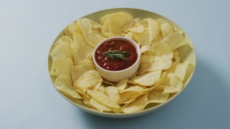 Cerca-De-Patatas-Fritas-En-Un-Recipiente-Con-Salsa-Sobre-La-Superficie-Azul