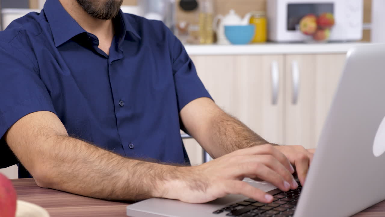 Man working on a laptop in the kitchen