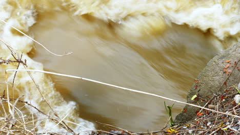 torrential floodwater rushing out of a culvert in a local sewerage system in thailand