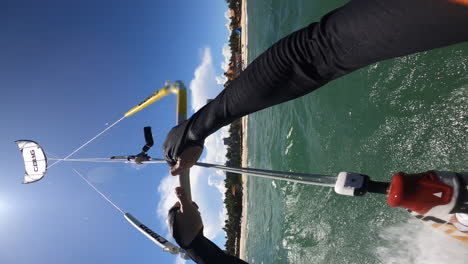 pov of a kite surfing doing acrobatic tricks on tropical ocean, vertical video