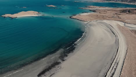 sandy shore of yttersand beach by the blue sea in fredvang, norway. - aerial shot