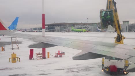 Enteisung-Des-Flugzeugs-Vor-Dem-Flug.-Anti-Icing-Ist-Die-Anwendung-Von-Chemikalien,-Die-Nicht-Nur-Enteisen,-Sondern-Auch-Auf-Einer-Oberfläche-Verbleiben-Und-Die-Neubildung-Von-Eis-Weiter-Verzögern