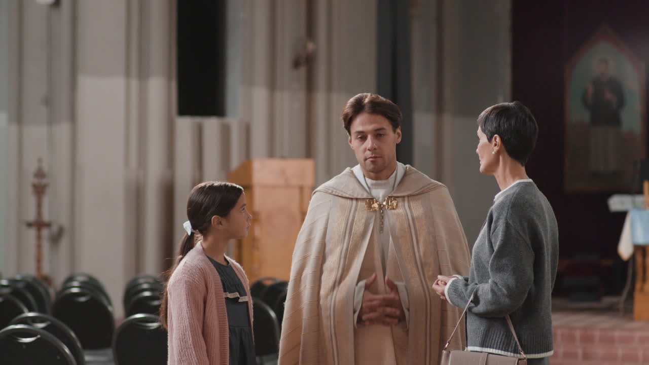 Family speaking with priest in church