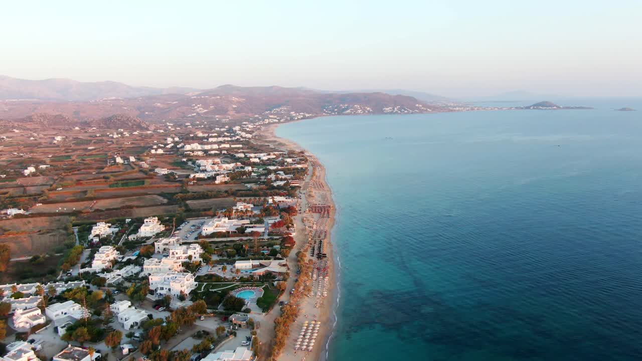 Aerial drone video panning down on big summer beach and colourful ocean