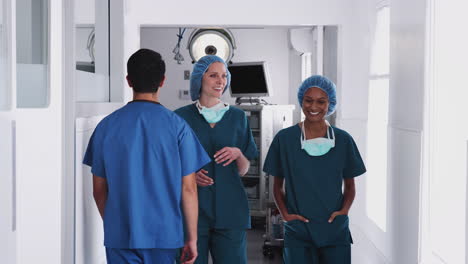 Zwei-Chirurginnen-In-Kitteln-Treffen-Sich,-Während-Sie-Gemeinsam-Den-Belebten-Krankenhauskorridor-Entlanggehen