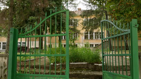 Green-painted-gates-to-dated-Eastern-European-education-school-building