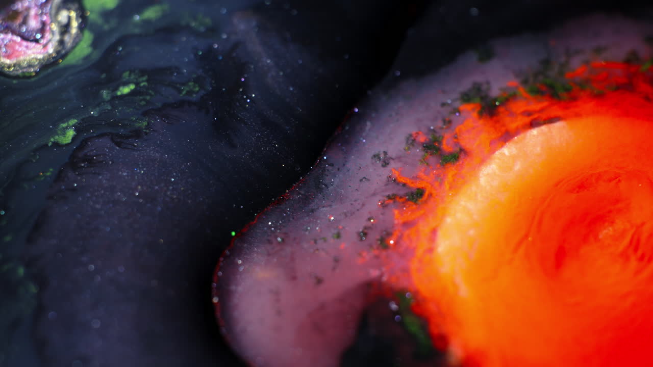 Colorful substances mix in a macro shot, creating dynamic abstract forms