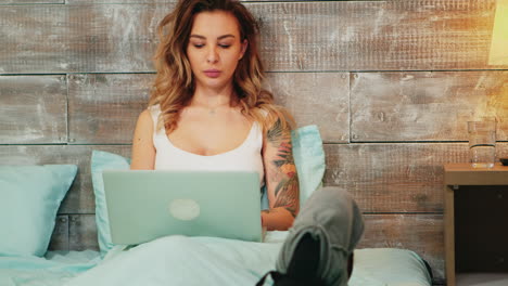 beautiful woman in pajamas doing online shopping on her laptop