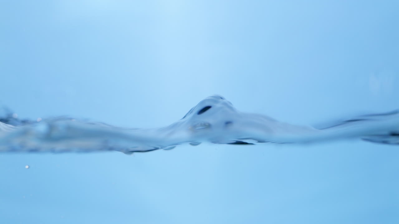 Beautiful slow-motion imagery of the water surface, showing vibrant blue waves and the purity of drinking water, perfect for health and wellness themes.
