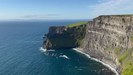 Nature-background:-Cliffs-of-Moher-rise-tall-out-of-calm-blue-ocean