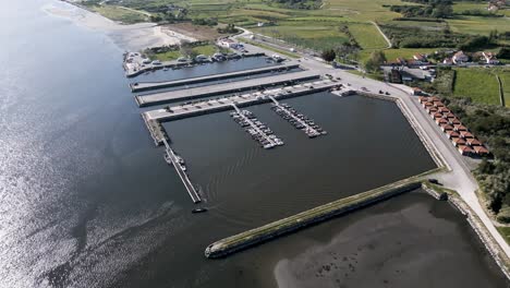 Aerial-view-of-Cais-do-Bico's-boat-docks,-a-tranquil-marina-in-Murtosa,-Aveiro,-set-against-the-Portuguese-coast