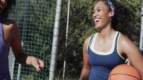 un equipo de baloncesto femenino feliz y diverso entrenando en una cancha soleada, en cámara lenta