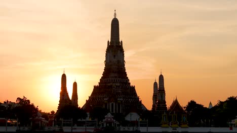 time-lapse of sunset behind a temple by a river