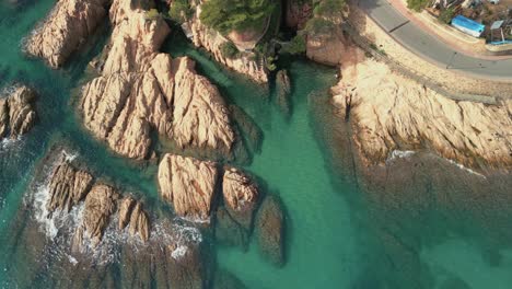 Vista-Aérea-De-Rocas-En-El-Mar-Mediterráneo-Azul-Turquesa-Transparente-Playa-De-Sant-Pol-En-S&#39;agar?