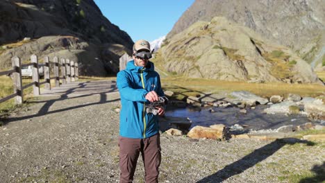 man flying drone outdoors with vr headset in valmalenco, italy