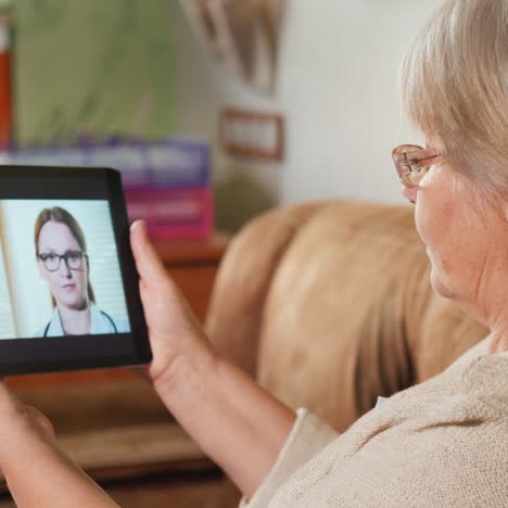 ältere-Frau-Konsultiert-Hausarzt-über-Videolink-Hält-Tablet
