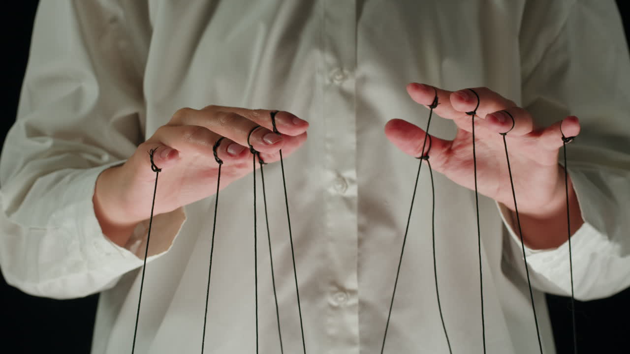 Hands of a Puppet Master Controlling Black Strings