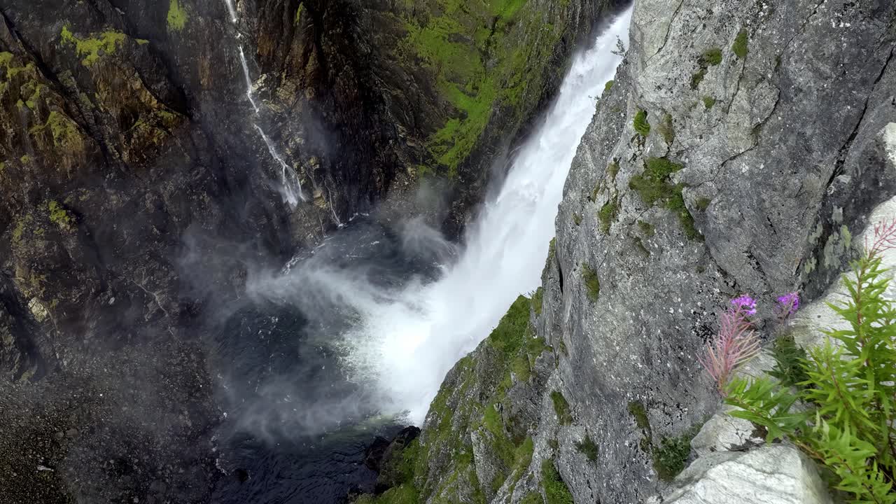 Powerful slow motion view of Voringsfossen waterfall in Hardangervidda, Norway, with mist, spray and canyon cliffs