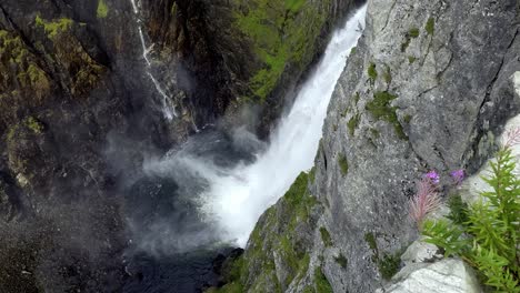 powerful slow motion view of voringsfossen waterfall in hardangervidda, norway, with mist, spray and canyon cliffs