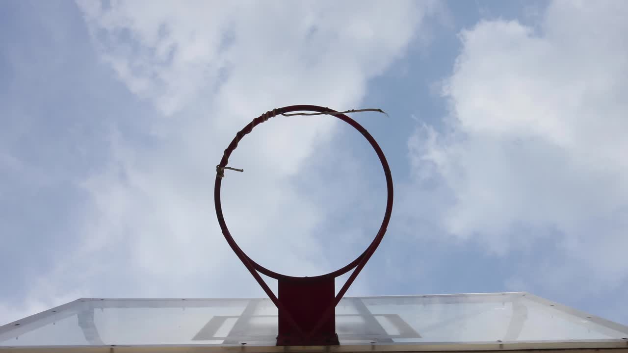 un aro de baloncesto con un fondo de nubes en movimiento