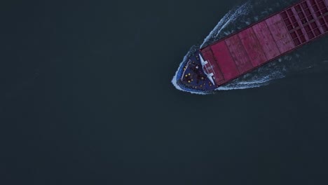 The-Rix-Union-Cargo-Vessel-Produces-a-White-Wake-as-it-Navigates-the-River-in-Zwijndrecht,-Netherlands---Aerial-Topdown-Shot