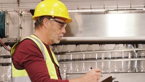 trabajador comprobando botellas en la línea de producción