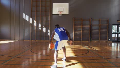 african american male basketball player practicing shooting with ball