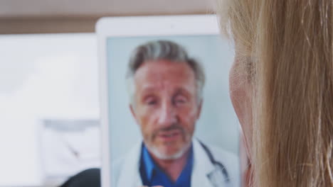 mature woman having online consultation with doctor at home on digital tablet
