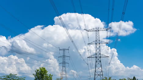 Time-Lapse-Of-Clouds-Above-Electricity-Pylon-Of-Electrical-Power-Transmission-Line-Under-Blue-Sky