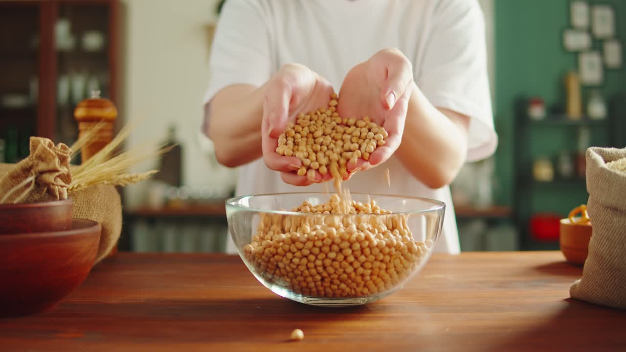 Hands handling chickpeas in a kitchen