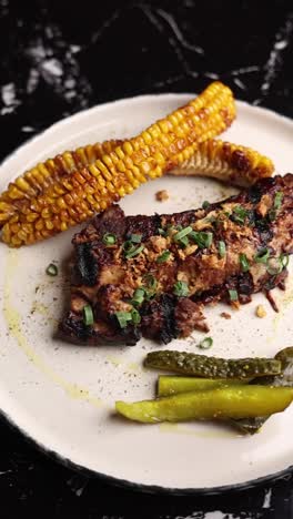 costillas de cerdo a la parrilla con maíz y pepinillos