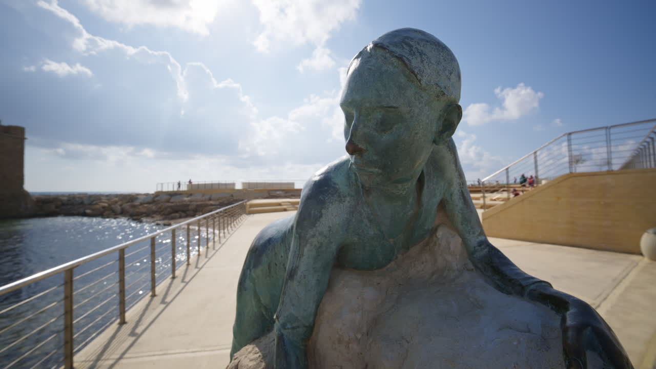 Pafo, Cipro - 26 febbraio 2026: Scultura artistica di una figura umana che abbraccia una roccia lungo la passeggiata lungomare.