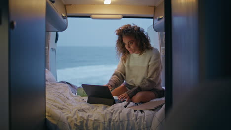 relaxed businesswoman looking laptop screen sitting trailer bed at twilight.