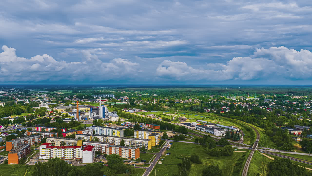 Piękny timelapse z lotu ptaka uchwycił chmury przemieszczające się po niebie nad europejskim miastem Jełgawa na Łotwie, ukazując jego dzielnice mieszkalne i przemysłowe.