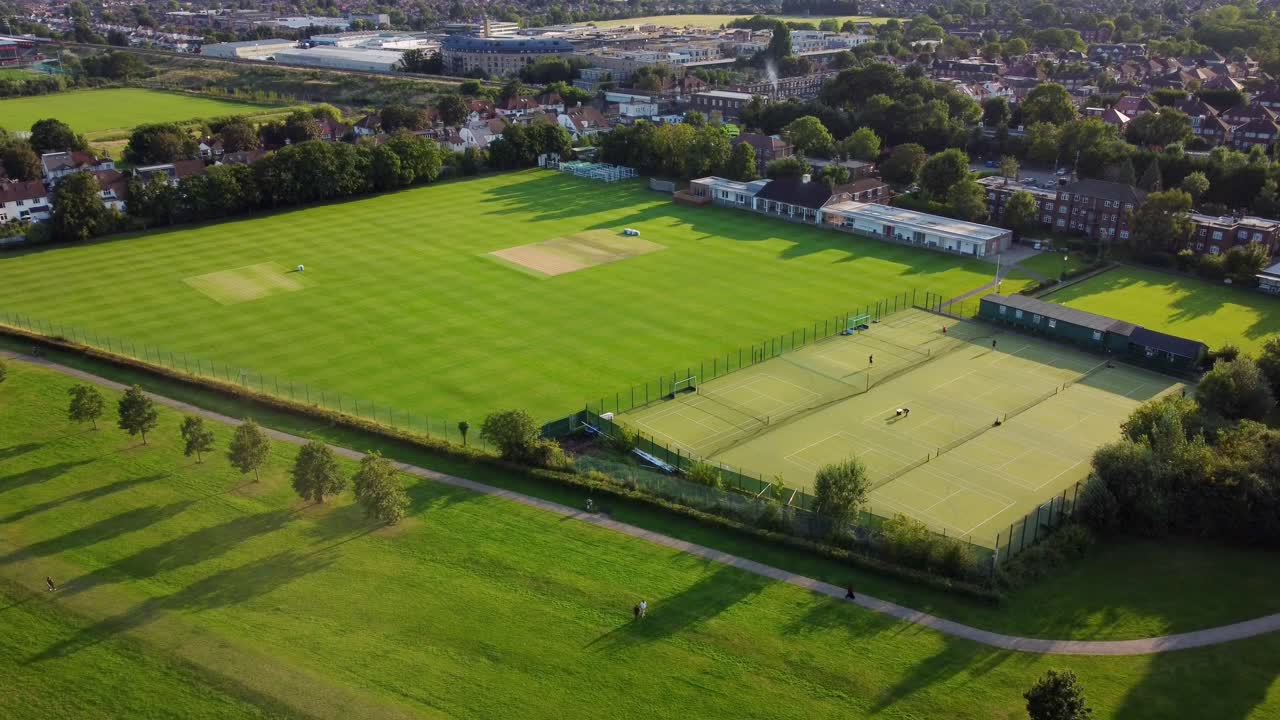 toma aérea de canons park en londres con campo de cricket y cancha de tenis