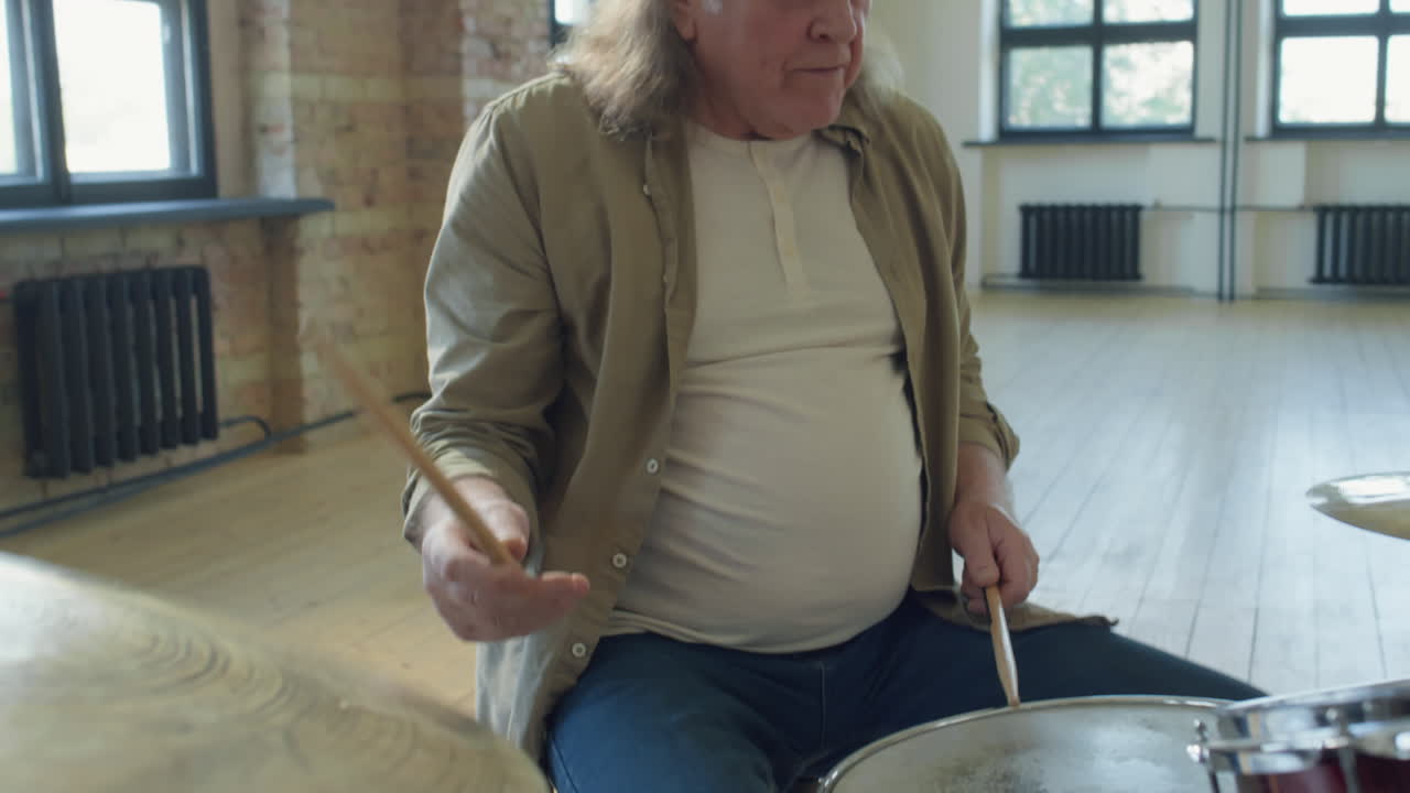 Senior Man Drumming in Music Rehearsal Studio