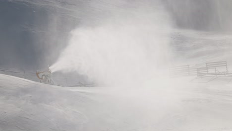 Maintenance-staff-on-snowmobile-driving-uphill-towards-blasting-snow-machine