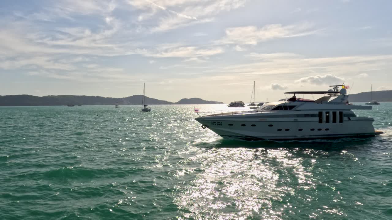 un yate de lujo se desliza a través de las aguas brillantes cerca de phuket, tailandia, bajo un cielo brillante, capturando la serena belleza costera