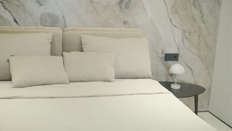 interior de dormitorio moderno con mesita de noche y pared de acento de mármol
