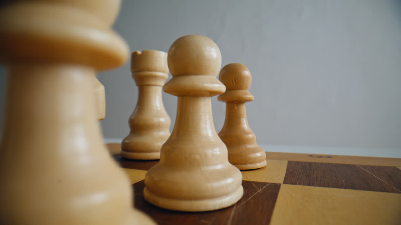 Light wooden chess figures positioned on board closeup. Pieces standing in row